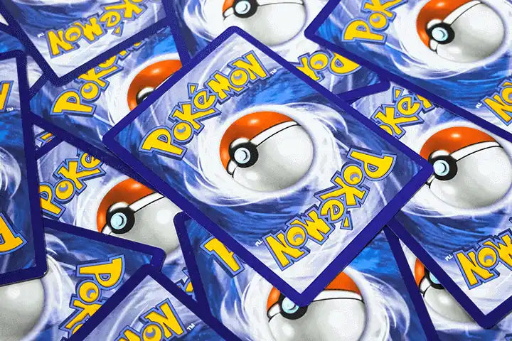 A scattered pile of Pokémon trading card backs.